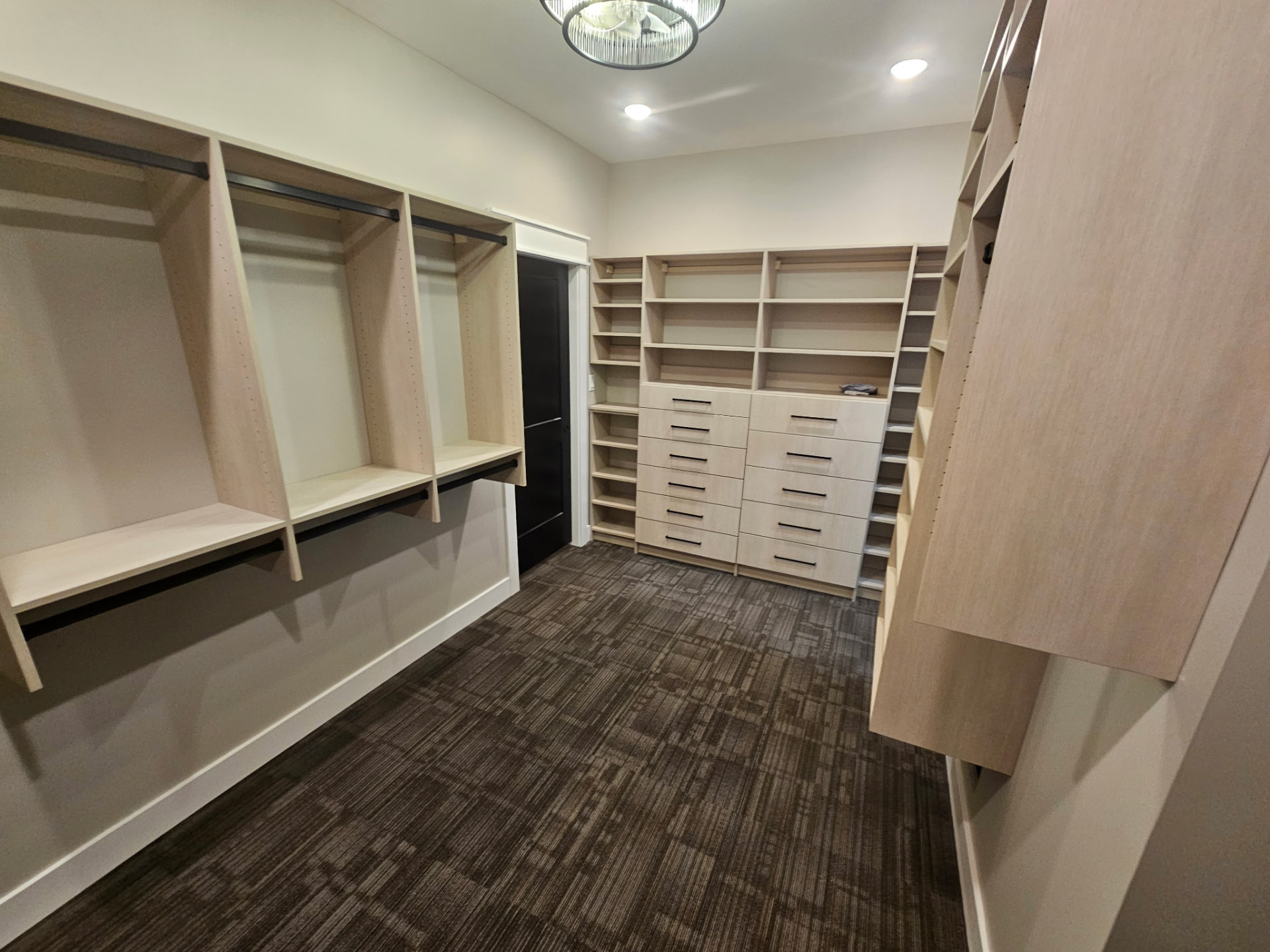 Custom walk-in closet with built-in shelving, drawers and hanging storage in a Midwest Custom Homes home.