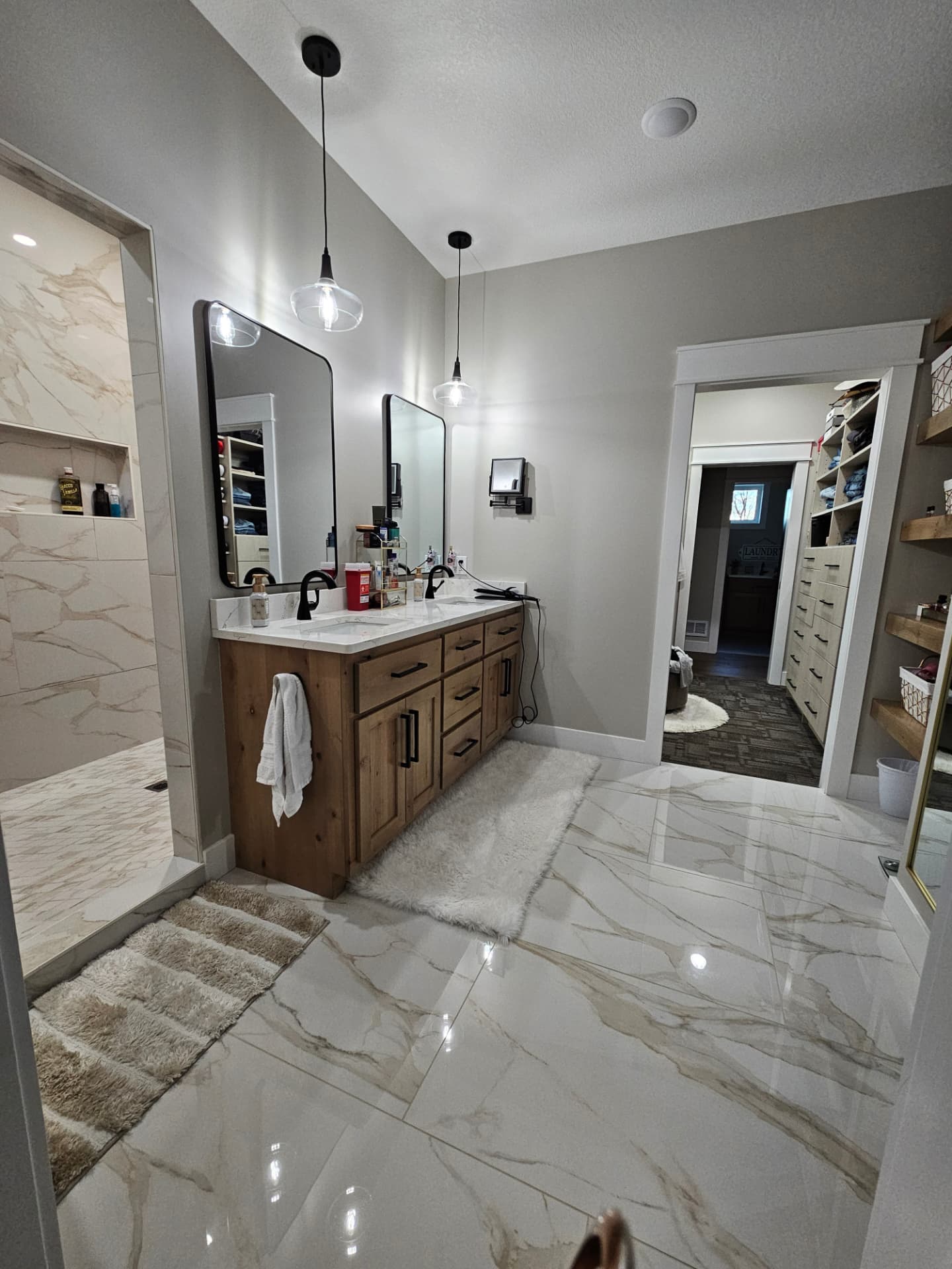 Custom primary bathroom with double vanity, walk-in shower and large-format tile in a Midwest Custom Homes home.